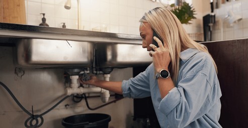 Emergency Plumbing Situations of water leakage from the pipeline Women Calling Plumber Immediately